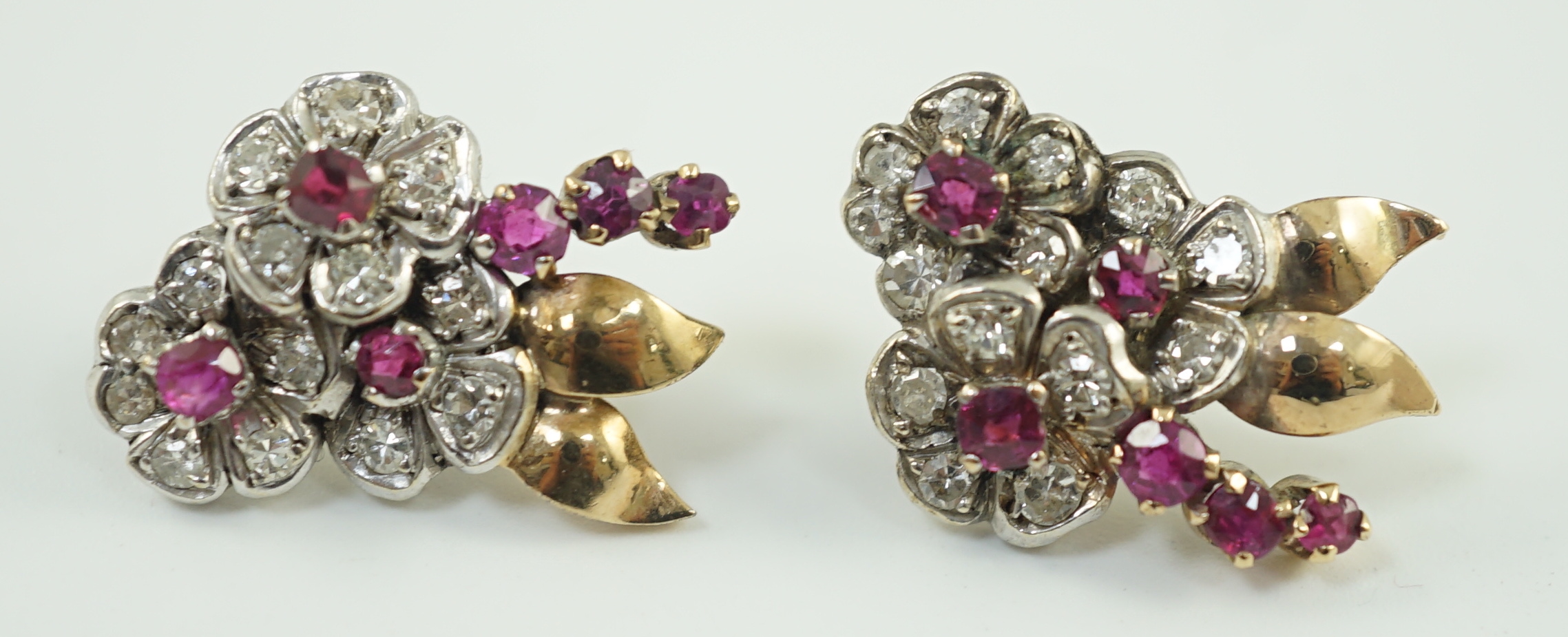 A pair of 1950's gold ruby and diamond set triple flower head cluster earrings